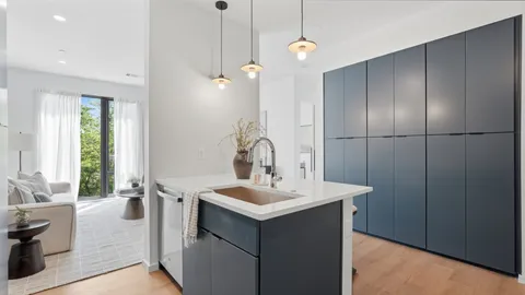 a kitchen with a sink a refrigerator and chandelier