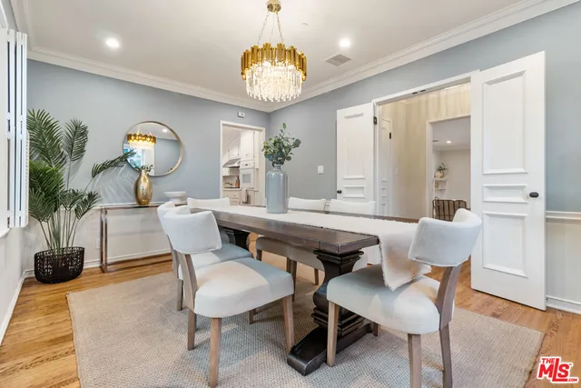 a view of a hallway with wooden floor and a bathroom