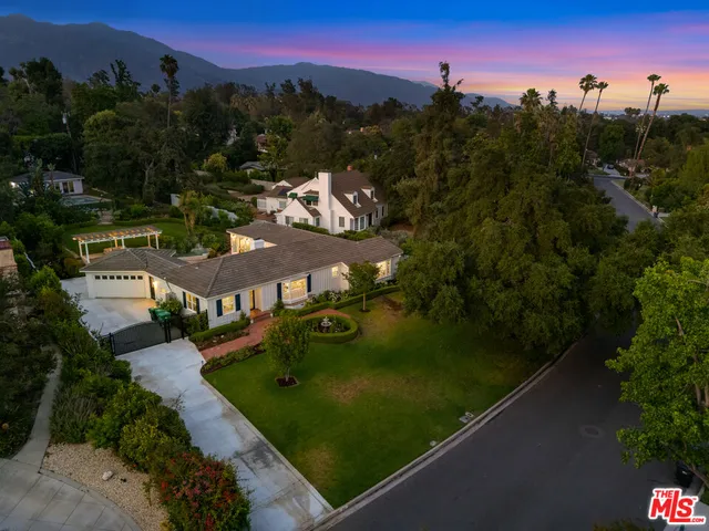 an aerial view of a house with a yard and large trees