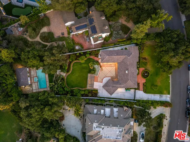 an aerial view of residential houses with outdoor space and trees