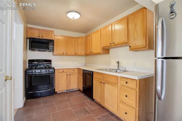 a kitchen with stainless steel appliances granite countertop a refrigerator sink and stove