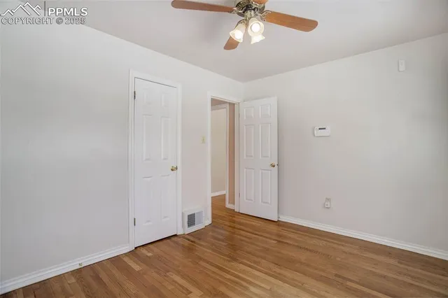 a view of an empty room with wooden floor