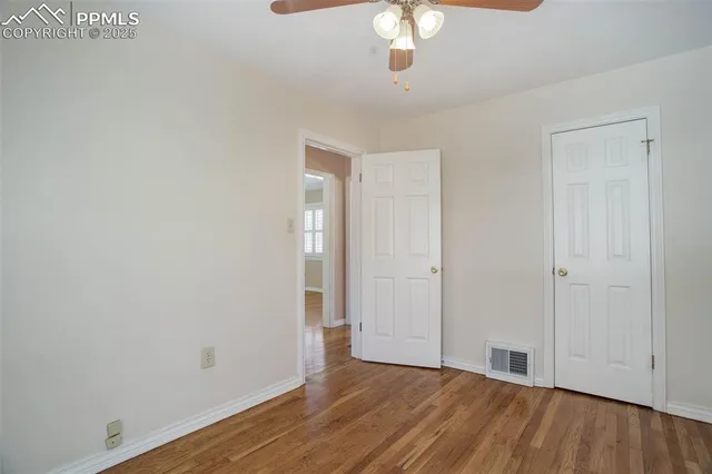 a view of an empty room with wooden floor