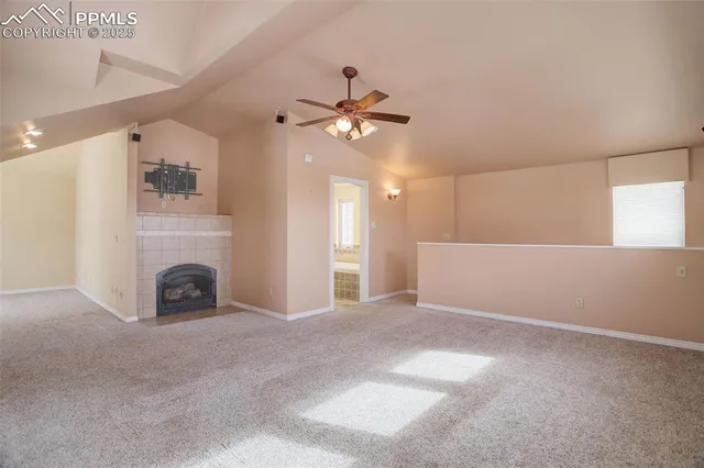a view of a livingroom with a fireplace and a ceiling fan