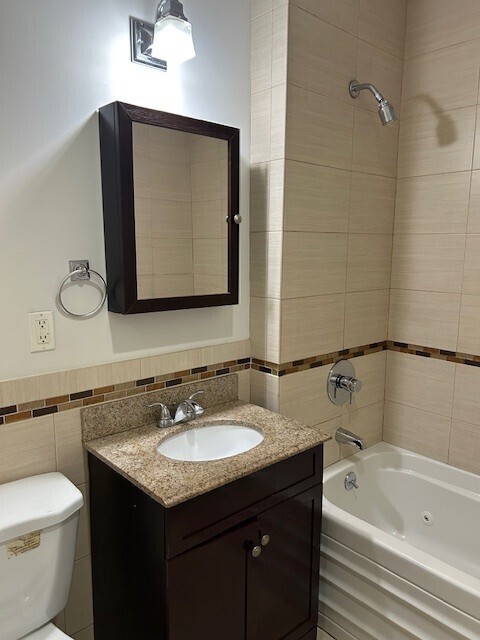 225 East 111th Street, Unit 3B Manhattan, NY 10029 - Photo 4 of 5 a bathroom with a granite countertop sink toilet and bathtub