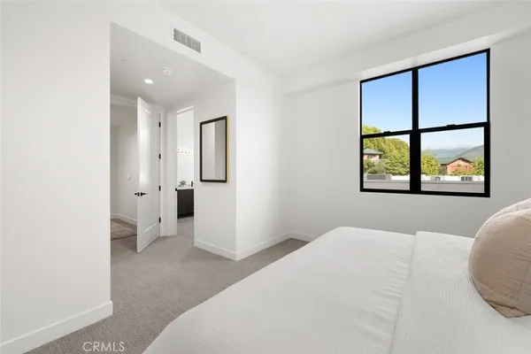 a spacious bedroom with a bed and a window