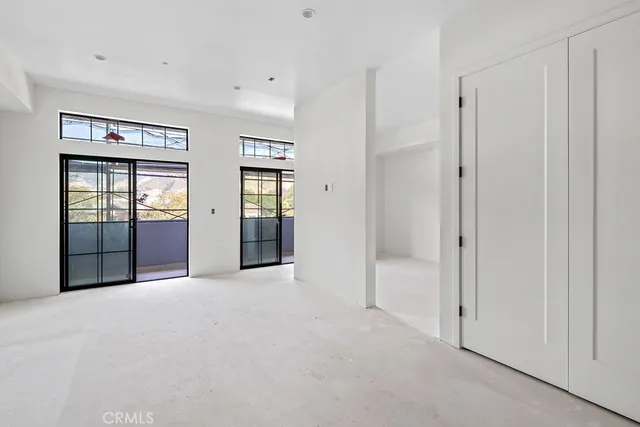 an empty room with windows and cabinet
