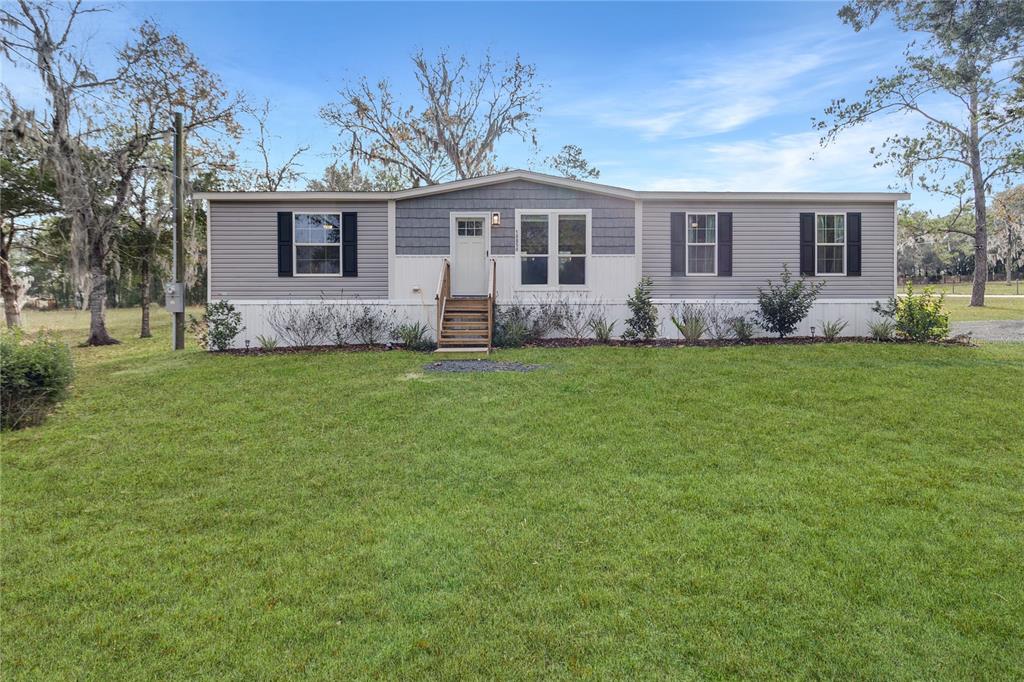 10850 Northeast 110th Lane Archer, FL 32618 - Photo 5 of 24 a front view of a house with a garden