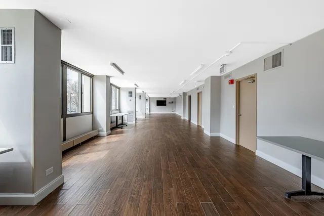 a hallway with wooden floor windows and stairs