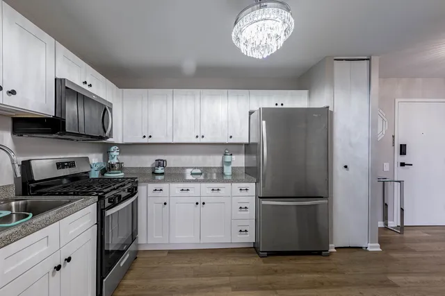 a kitchen with a refrigerator a stove a microwave and cabinets