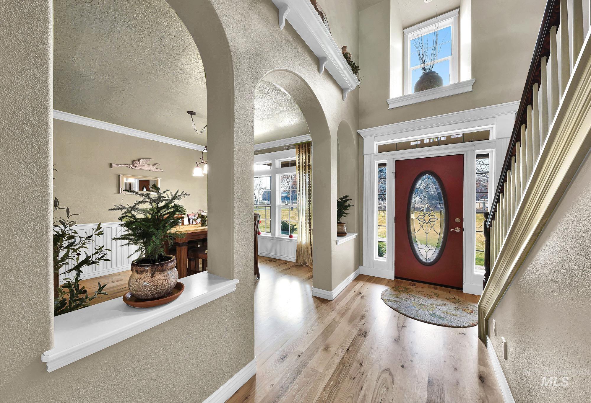 19288 Majestic View Place Caldwell, ID 83607 - Photo 13 of 50 Entrance foyer featuring arched walkways, a textured wall, light wood-style flooring, and a textured ceiling