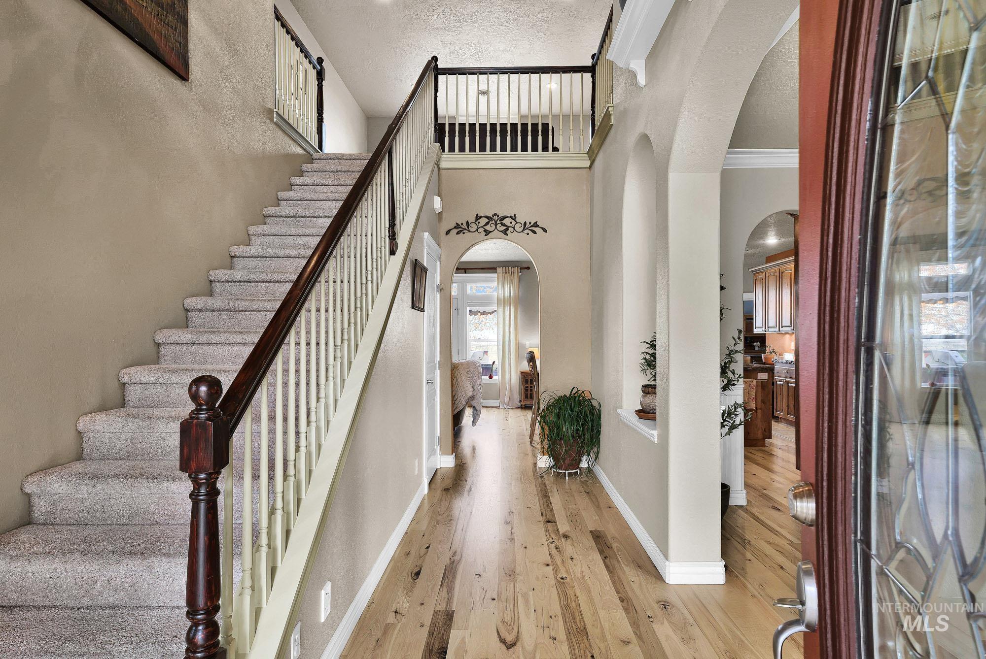19288 Majestic View Place Caldwell, ID 83607 - Photo 24 of 50 Foyer entrance featuring arched walkways, light wood-type flooring, a high textured ceiling, and ornamental molding