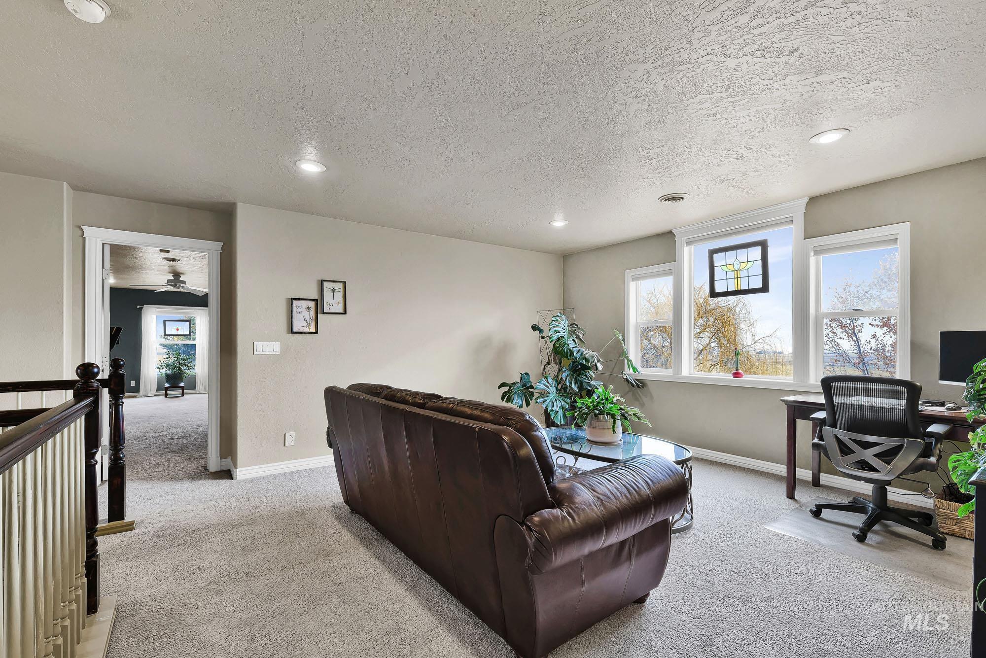 19288 Majestic View Place Caldwell, ID 83607 - Photo 26 of 50 Living room with light carpet, a desk, a textured ceiling, and recessed lighting
