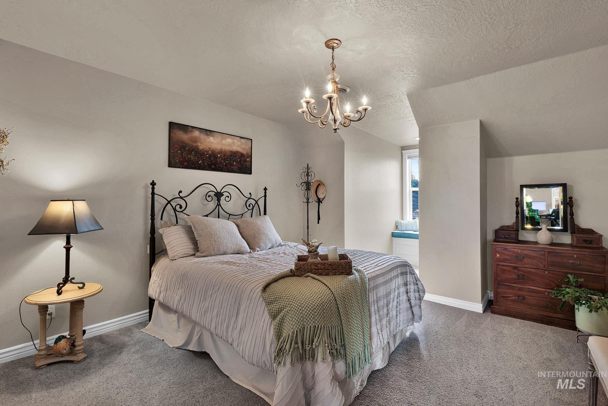 19288 Majestic View Place Caldwell, ID 83607 - Photo 30 of 50 Bedroom featuring a unique window seat, a chandelier, and carpet flooring