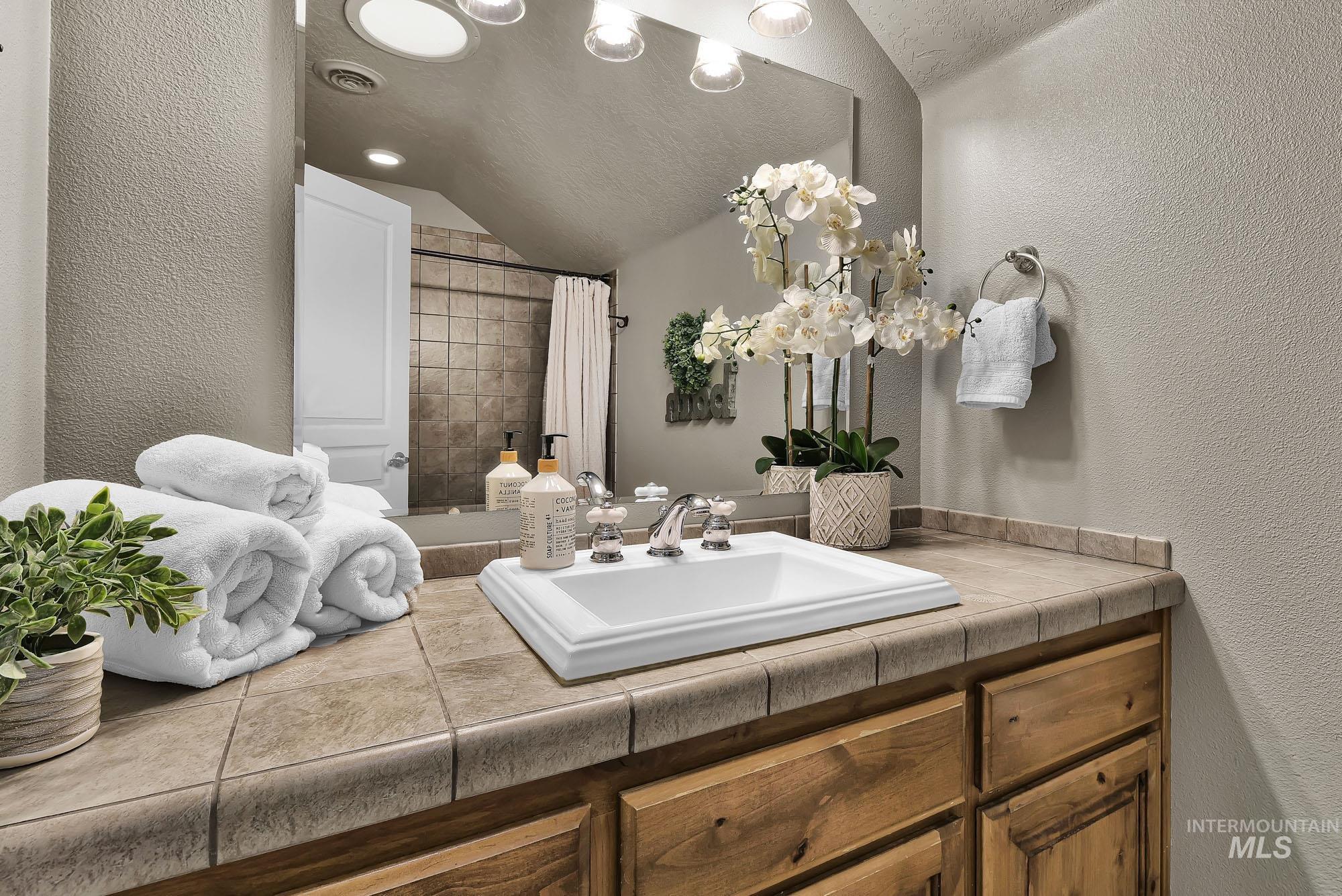 19288 Majestic View Place Caldwell, ID 83607 - Photo 31 of 50 Full bath with a textured wall, skylight, vanity, tiled shower, and recessed lighting