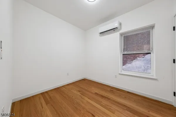 an empty room with a wooden floor and a window