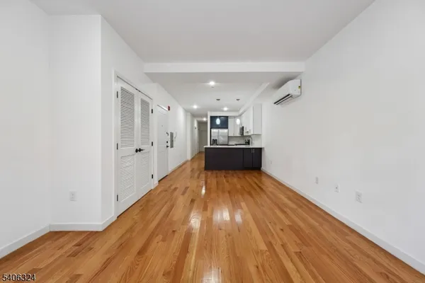 a view of empty room with wooden floor