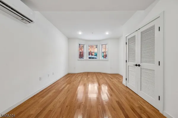 a view of hallway with wooden floor and a window