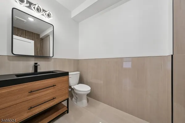 a bathroom with a toilet a sink and mirror