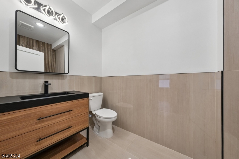 52 James Street, Unit 1 Newark, NJ 07102 - Photo 9 of 28 a bathroom with a toilet a sink and mirror