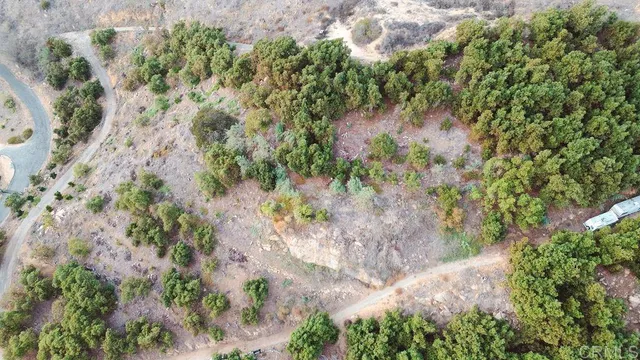 an aerial view of residential house with outdoor space and trees all around