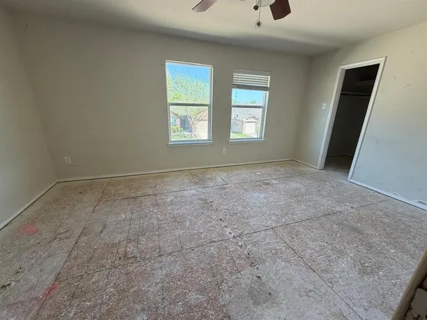 an empty room with wooden floor and mirror
