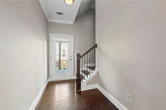 a view of a hallway with wooden floor and stairs