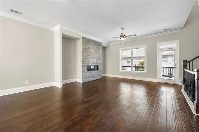 a view of an empty room with window and wooden floor