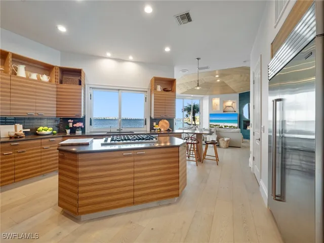 a kitchen with kitchen island stainless steel appliances a sink stove and refrigerator