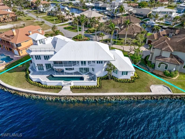 an aerial view of a house with a yard and lake view