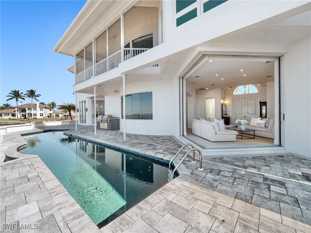 a large white kitchen with kitchen island granite countertop a large counter top and stove in it