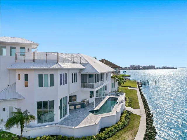 a front view of a house with a garden and lake view