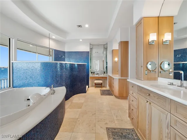 a bathroom with a tub sink and mirror