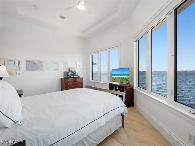 a bedroom with a large bed and a flat tv screen on dresser