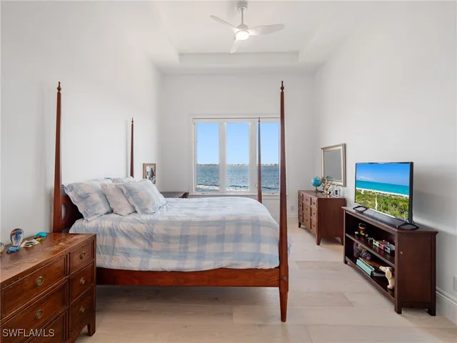 a bedroom with a bed and a flat tv screen on dresser