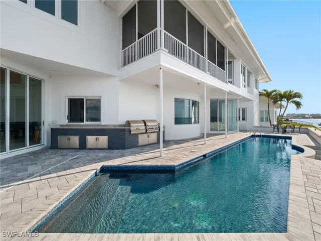 a view of a house with swimming pool and sitting area