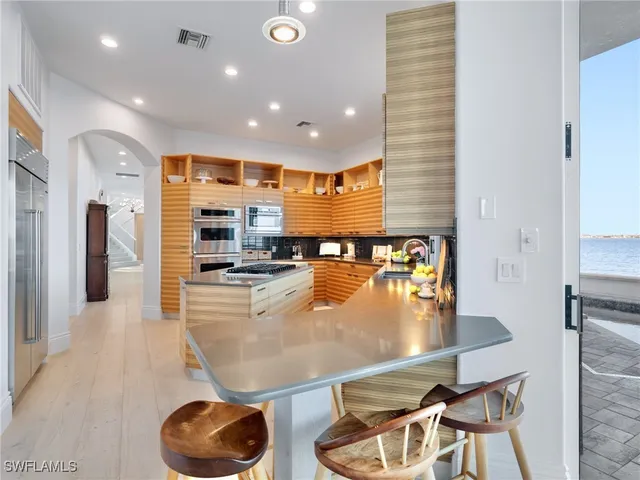 a large kitchen with stainless steel appliances granite countertop a refrigerator and a stove top oven