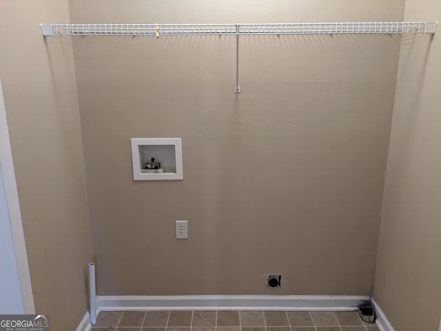 an empty room with a chandelier fan and windows