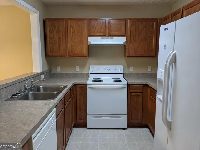a kitchen with a refrigerator sink and cabinets