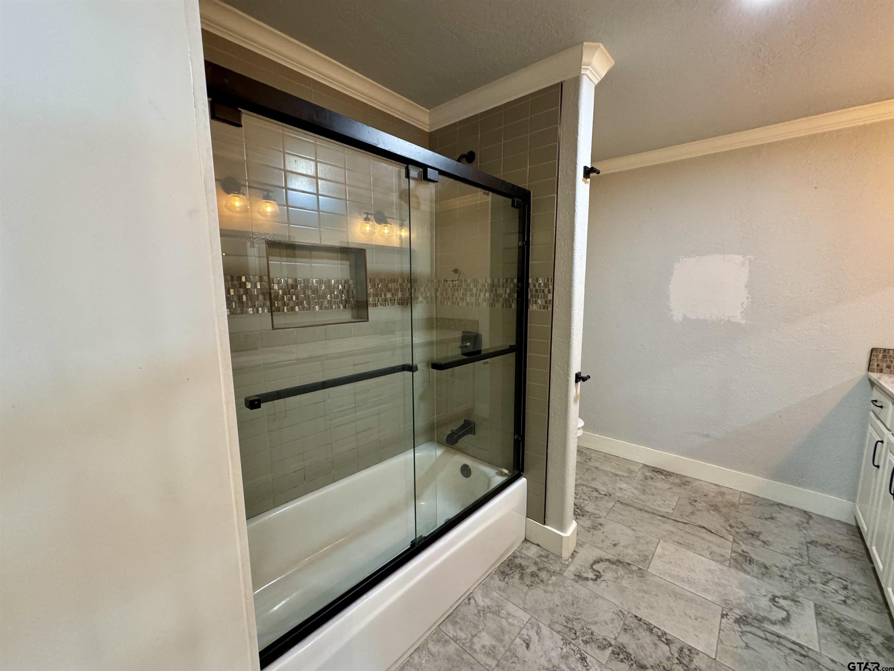 403 East Henderson Street Overton, TX 75684 - Photo 11 of 31 a bathroom with a glass shower door