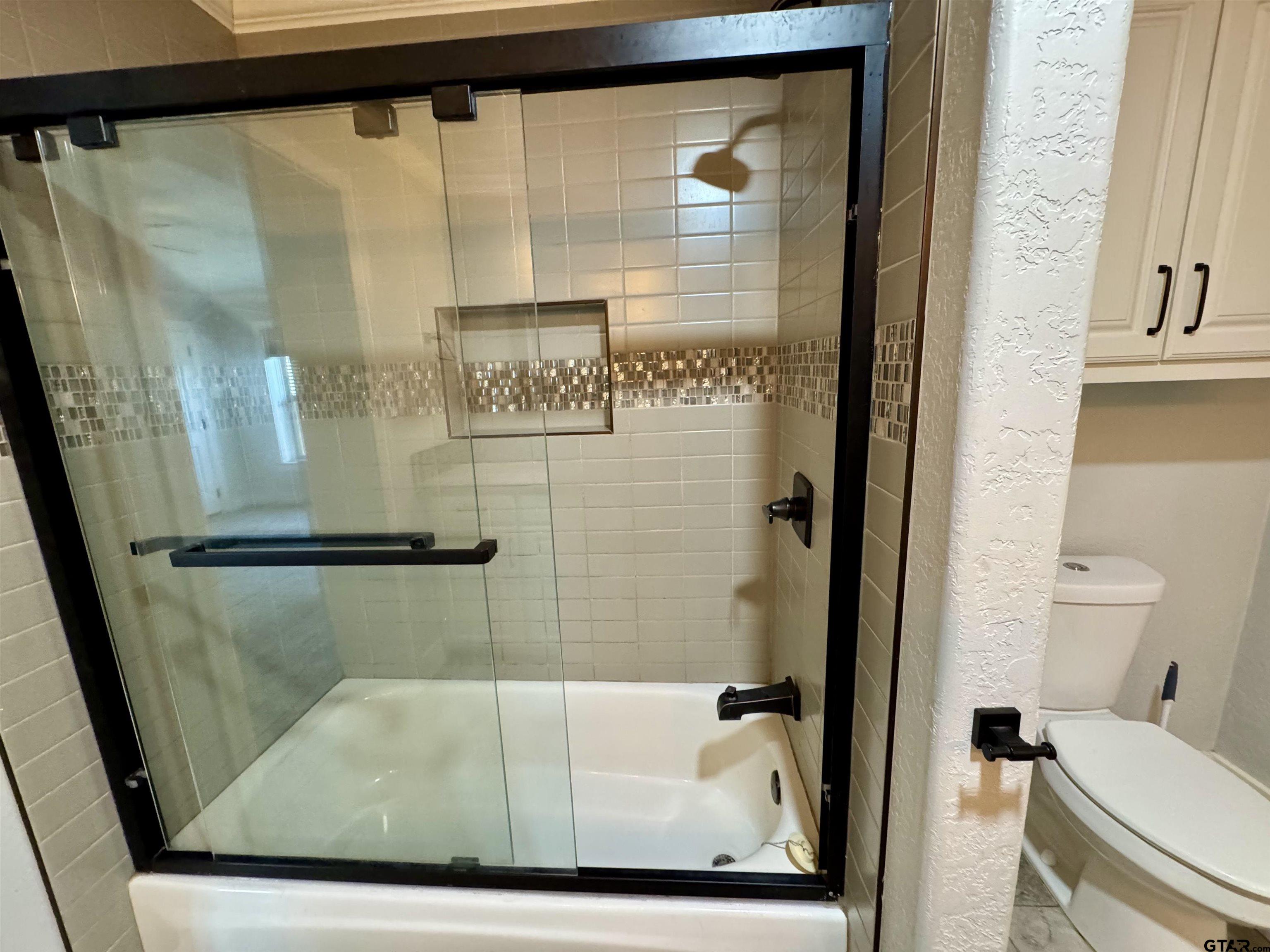 403 East Henderson Street Overton, TX 75684 - Photo 12 of 31 a bathroom with a shower and toilet