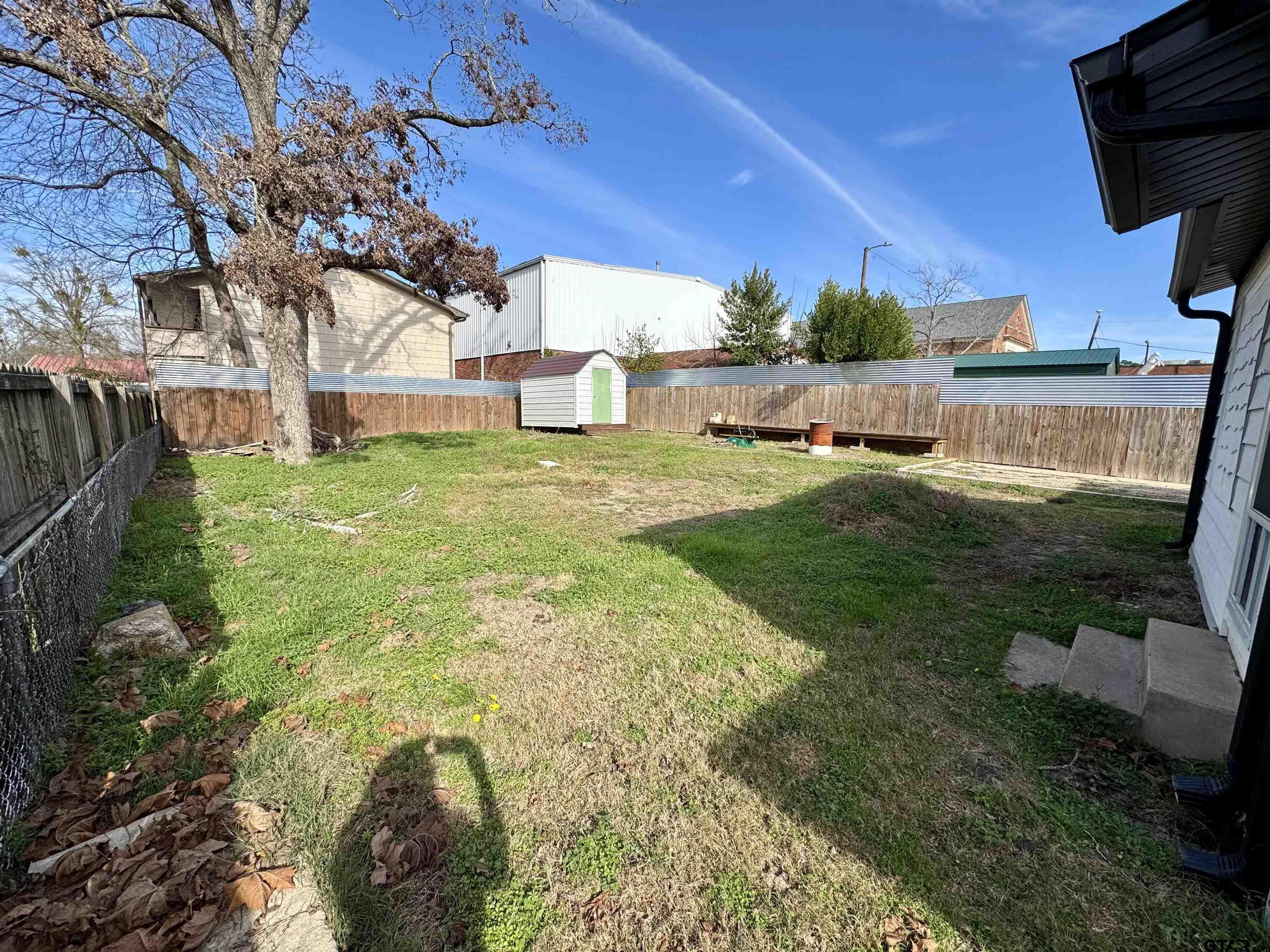 403 East Henderson Street Overton, TX 75684 - Photo 20 of 31 a backyard of a house with table and chairs plants and large tree