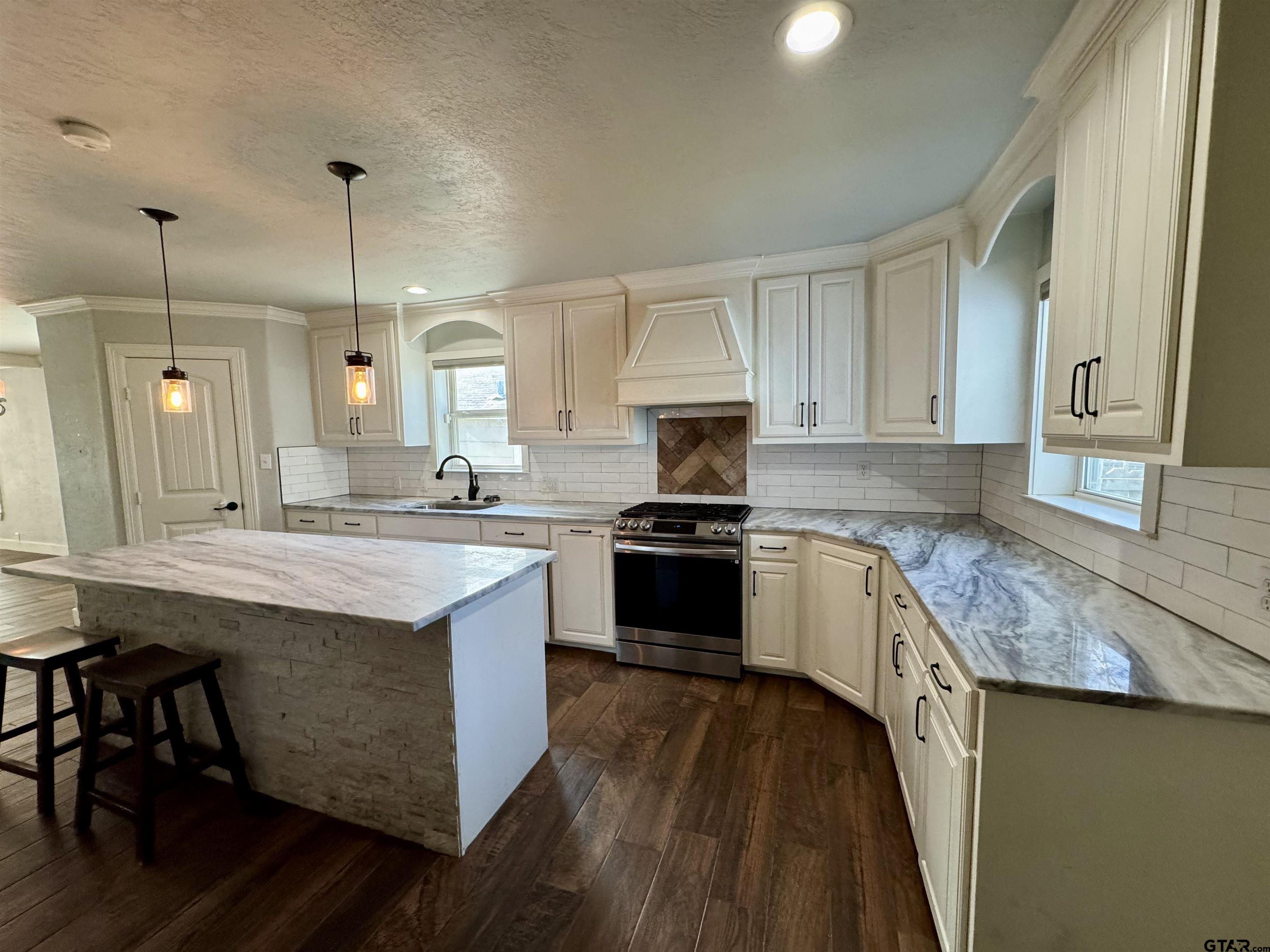 403 East Henderson Street Overton, TX 75684 - Photo 3 of 31 a kitchen with stainless steel appliances granite countertop wooden cabinets sink and stove