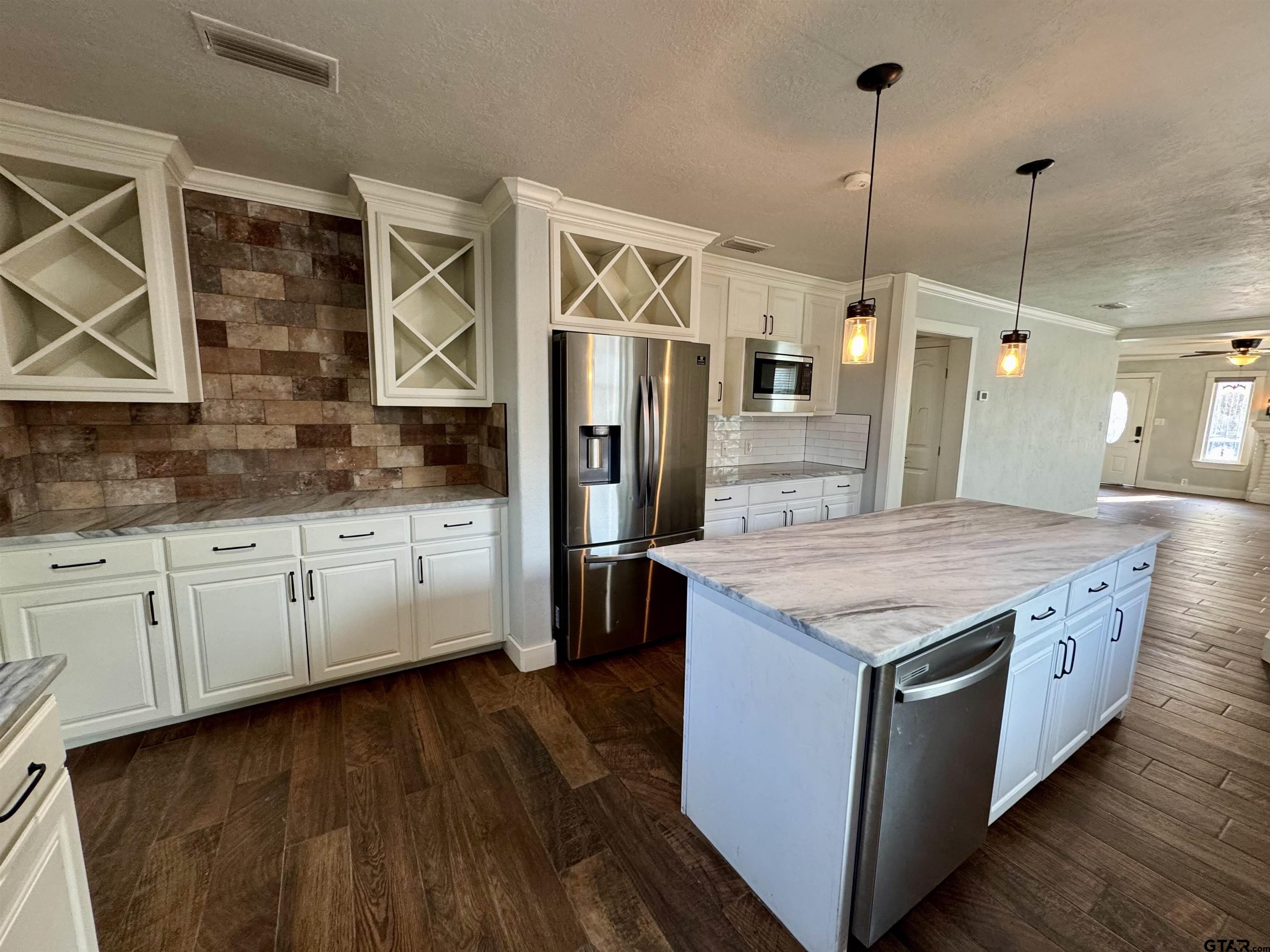 403 East Henderson Street Overton, TX 75684 - Photo 4 of 31 a kitchen with stainless steel appliances granite countertop a sink a stove and a wooden floor
