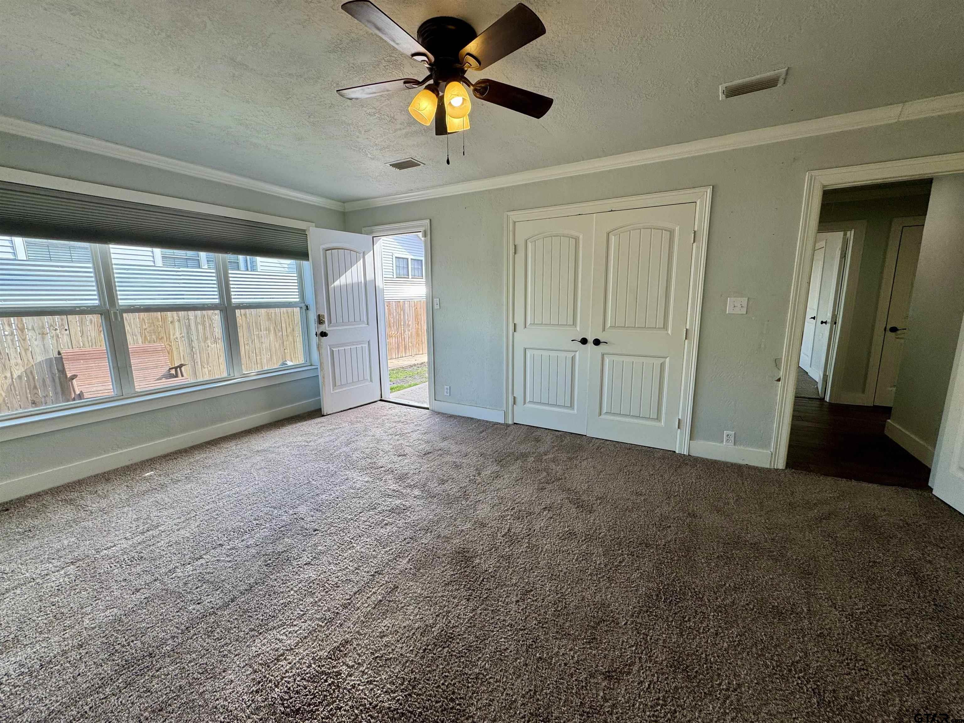 403 East Henderson Street Overton, TX 75684 - Photo 9 of 31 en empty room with windows and chandelier fan