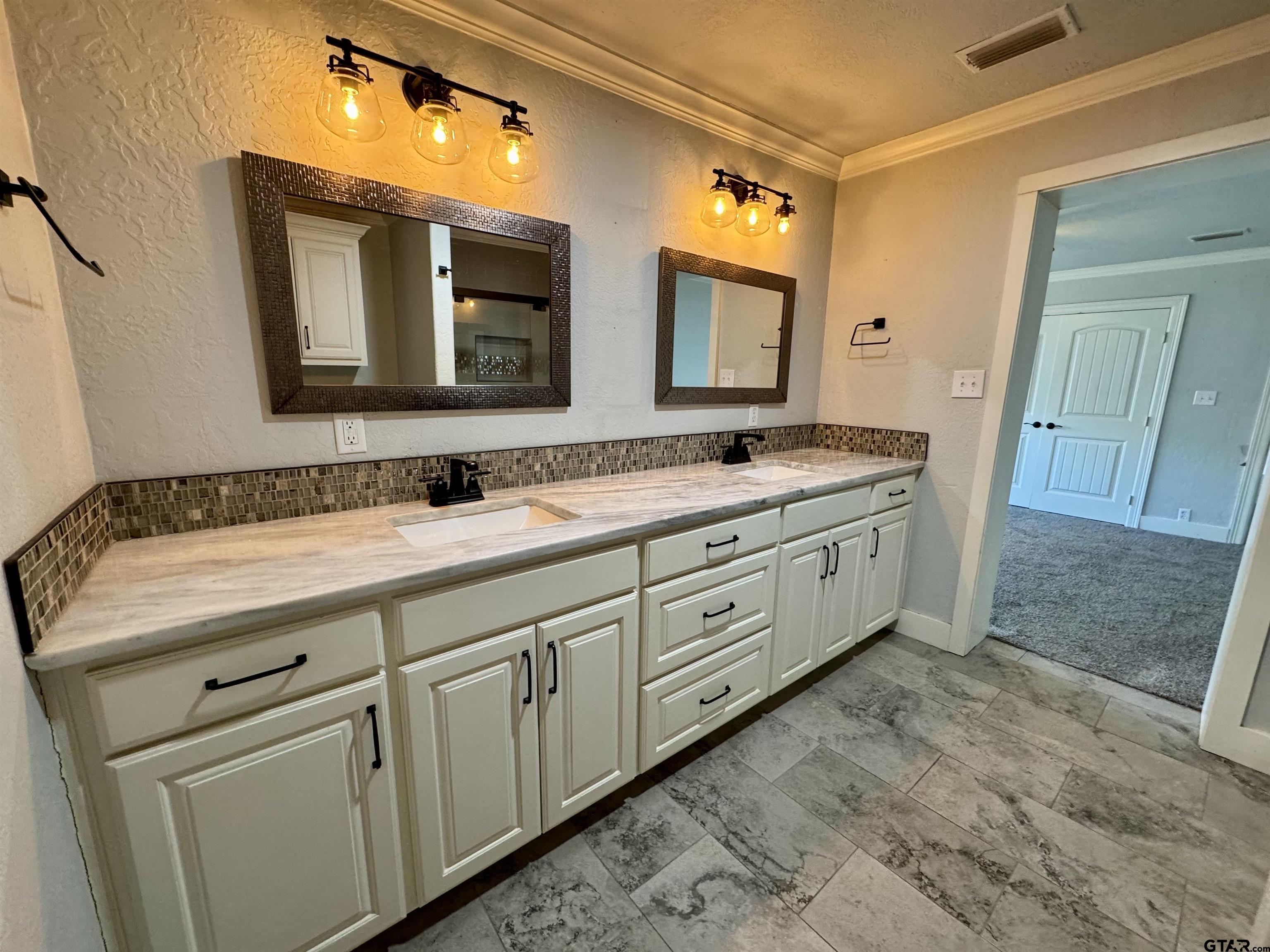 403 East Henderson Street Overton, TX 75684 - Photo 10 of 31 a bathroom with a double vanity sink and a mirror