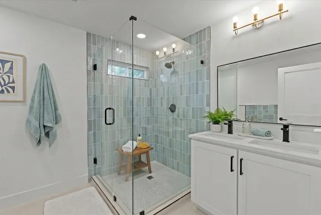 a bathroom with a shower sink and mirror