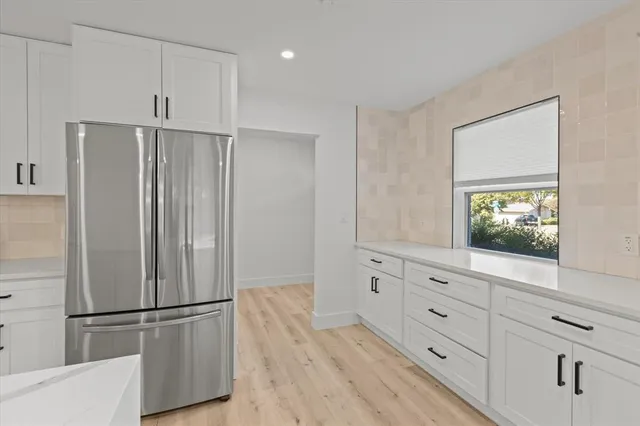 a kitchen with white cabinets and white appliances