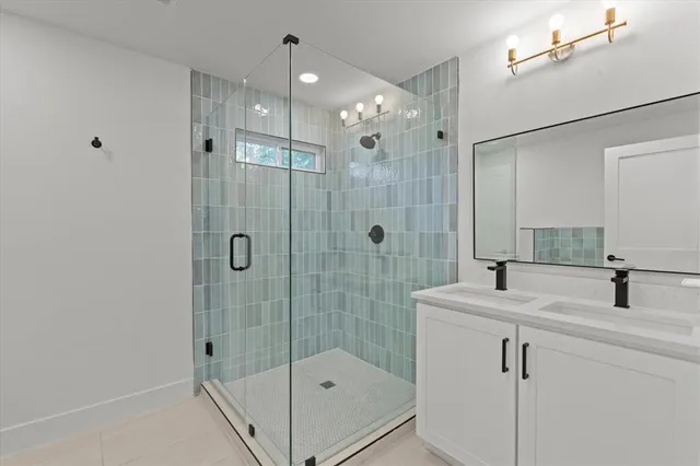 a bathroom with a shower sink and mirror