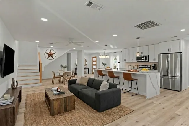a living room kitchen with furniture and a flat screen tv